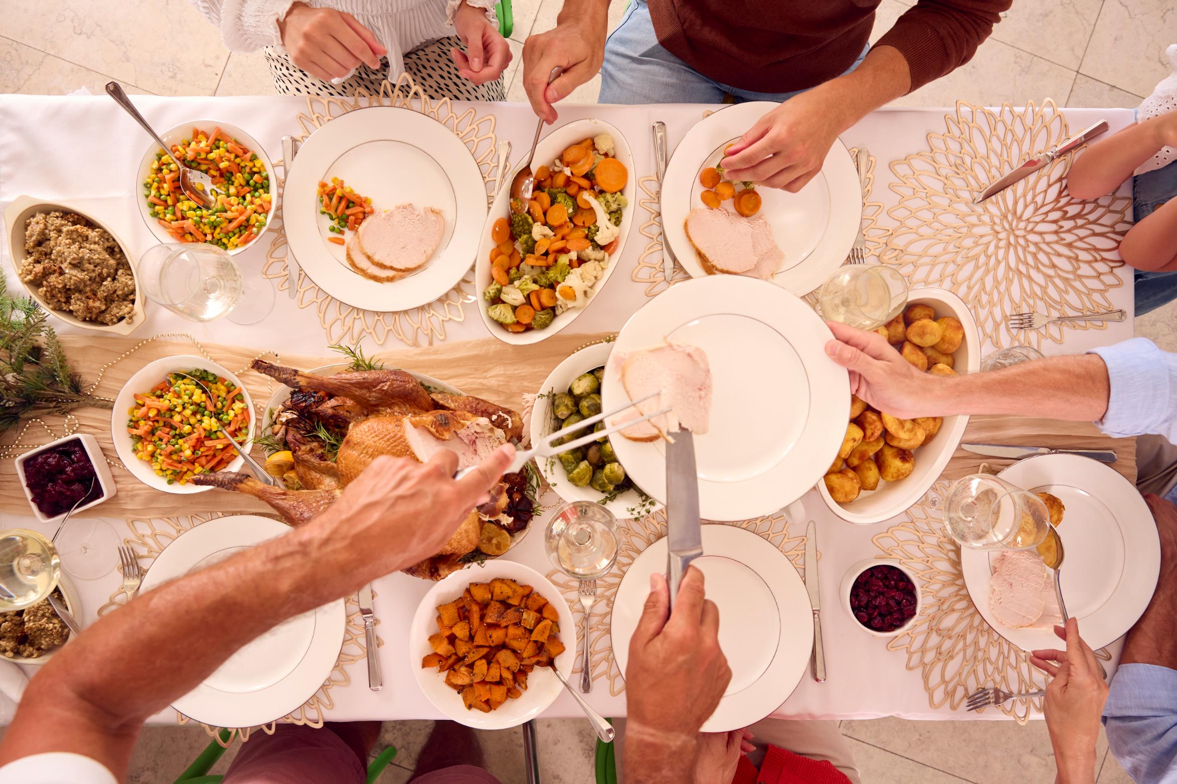 overhead-shot-of-multi-generation-family-celebrati-2023-11-27-04-58-06-utc Holiday Family Dinner